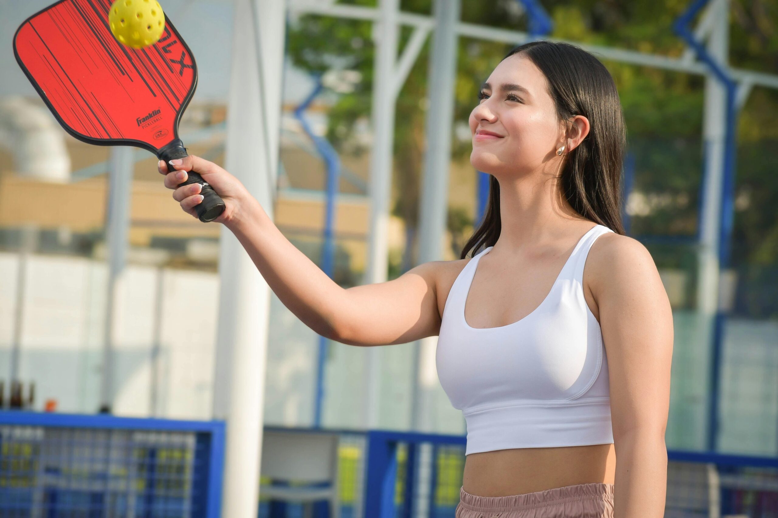 A woman holding a pickleball paddle.